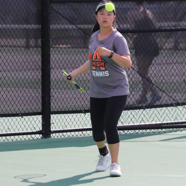 Ames tennis player stares at a tennis ball, about to return serve