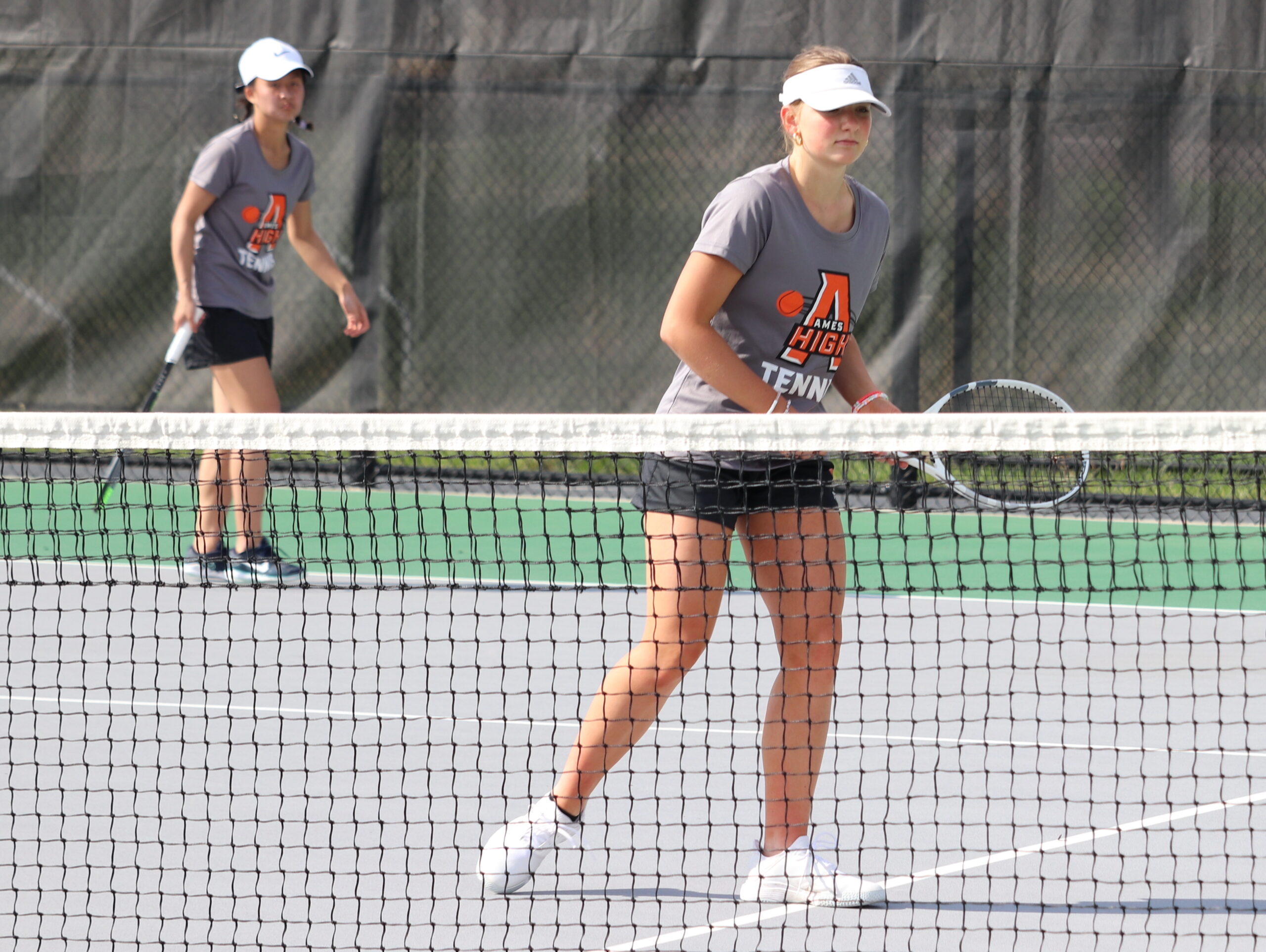 Ames tennis doubles team shifts awaiting the serve