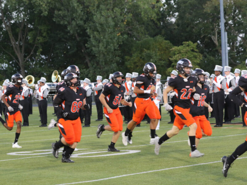 Football players running onto the field