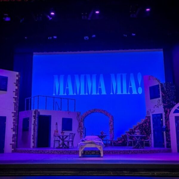 Stage set for Mamma Mia with title projected behind it