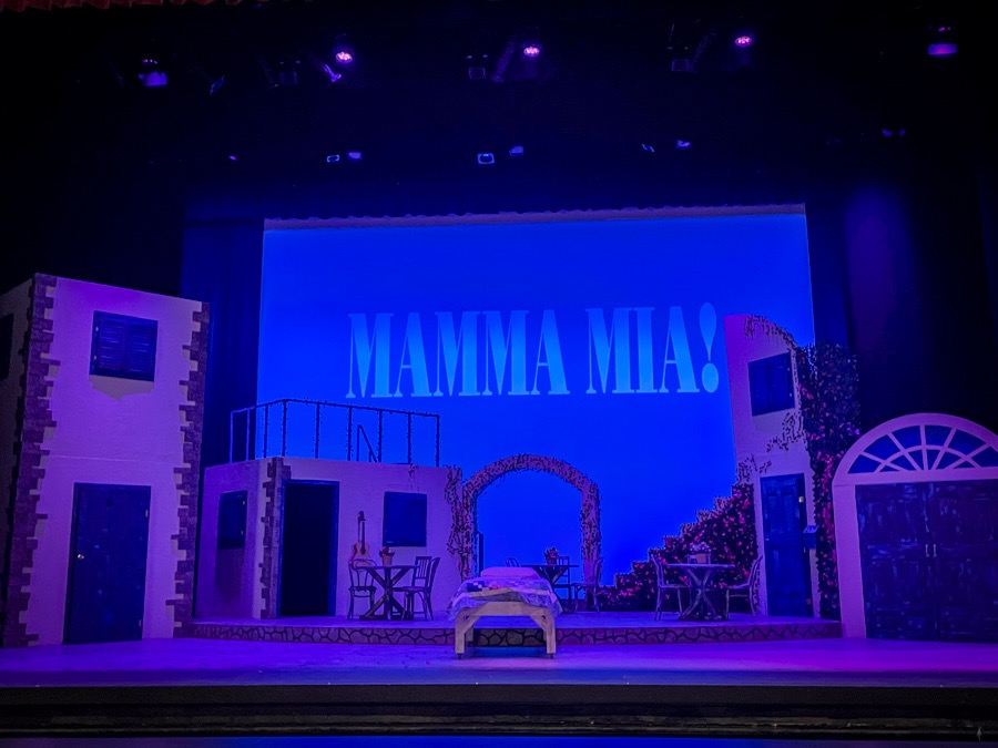 Stage set for Mamma Mia with title projected behind it