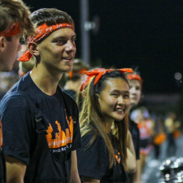 The band drumline smiles while waiting to play