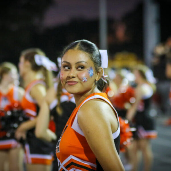 A cheerleader smiles during the football game