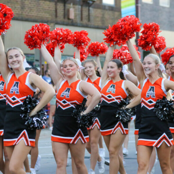 cheerleaders raise their pom poms in the parade