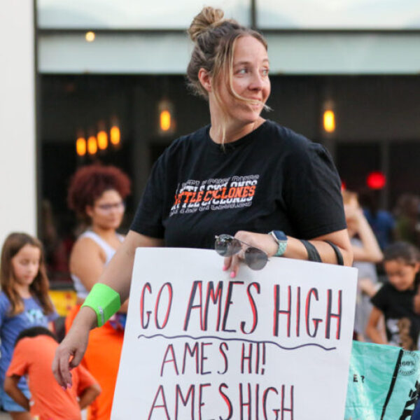 An Ames Middle School teacher smiles in the parade