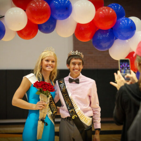 Homecoming king and queen smile for picture takers