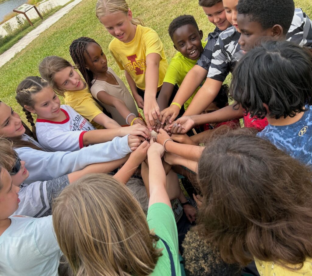 Students putting their hands in together for a cheer